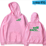 Pink hoodie with 'self care.' text on front and back, displayed from front and back views.