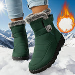Green winter boots with fur trim worn in the snow, with a fiery graphic in the corner.