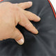 Hand touching a black surface with red edges