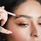 Person applying eyebrow makeup with a pencil