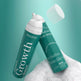 Two green bottles of PHOFAY Growth hair product on a white surface with a teal background