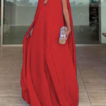 Red evening gown with a cape worn by a person indoors.