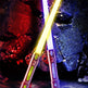 Due spade laser con lame colorate su sfondo roccioso e alieno.