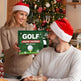Two people wearing Santa hats in a festive setting with a golf advent calendar.