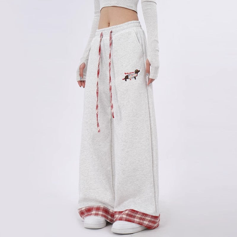 White sweatpants with red plaid accents and a small graphic on a white background