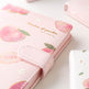 Pink notebook with peach illustrations on a light surface