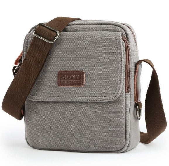 Gray shoulder bag with brown strap and visible brand logo on a white background