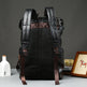 Black leather backpack on a gray surface with a dark background