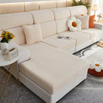 Beige sectional sofa in a living room setting with decorative pillows and a small table.