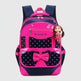 Pink and navy backpack with a bow and polka dots, featuring a doll on a white background.