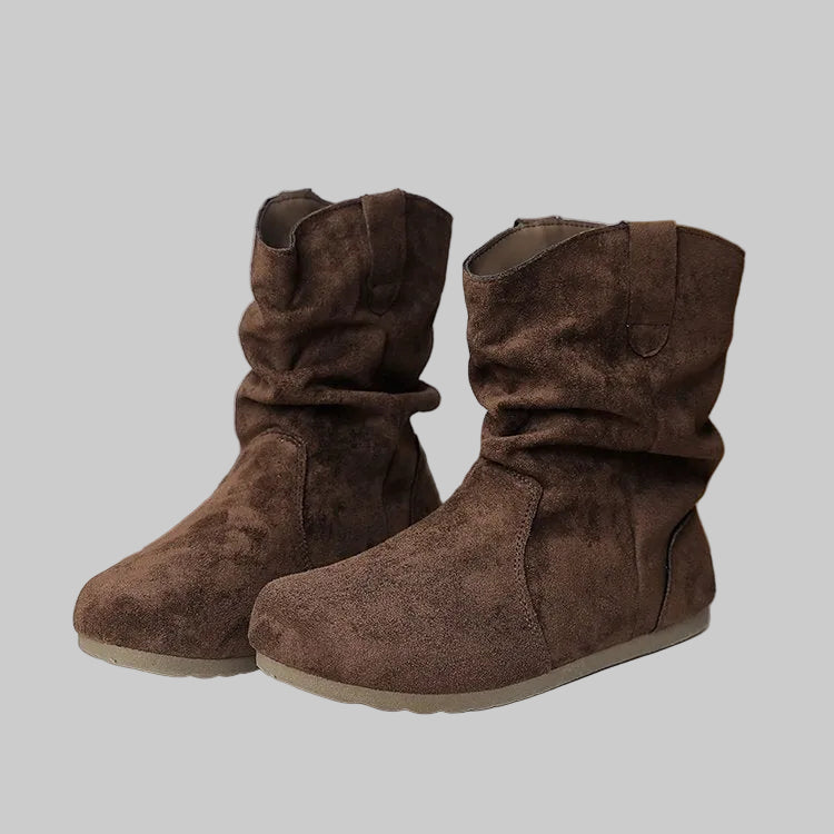 Pair of brown suede boots on a white surface with a gold border.
