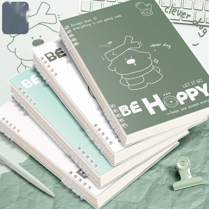 Stack of notebooks with a cartoon dog illustration and text on a green surface.
