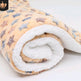 Rolled-up blanket with a floral pattern on a white background