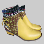 Pair of colorful boots with a yellow sole on a workshop table.