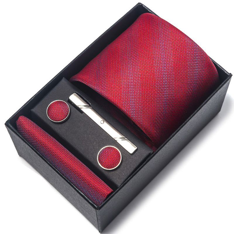 Red tie set with pocket square, cufflinks, and tie clip in a black box on a white background
