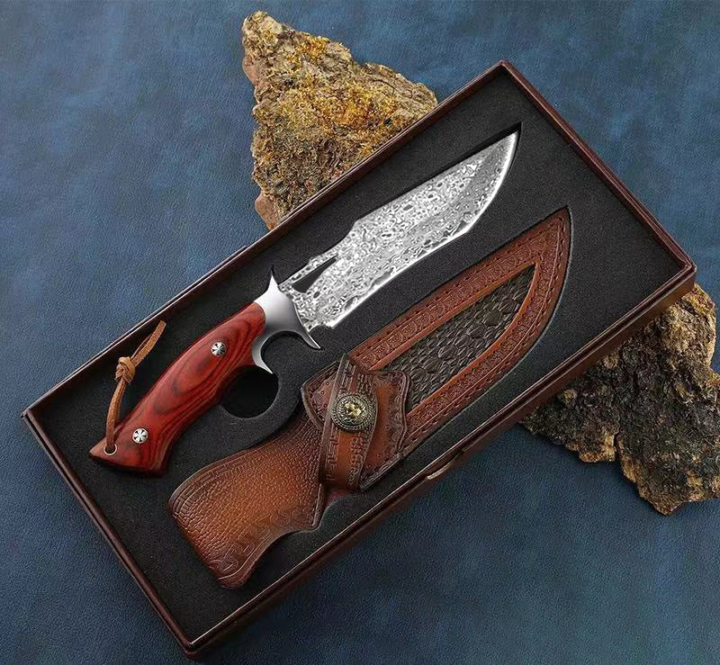 Decorative knife with a wooden handle and leather sheath on a textured surface