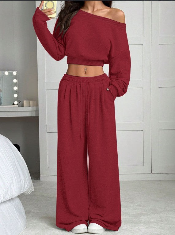 Person wearing a red outfit with a matching top and wide-leg pants in a room.