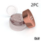 Open jar of glittery makeup with rose gold lid on a white background