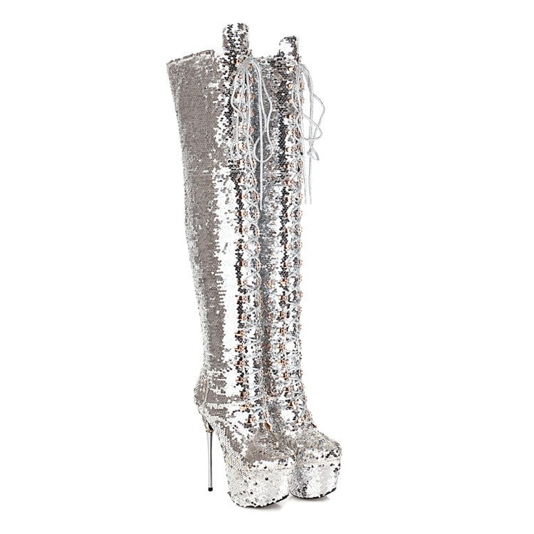 A pair of silver sequined thigh-high boots with platform soles and high stiletto heels, featuring white lace-up detailing on the front.