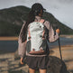 Person hiking with a backpack and walking stick in a mountainous area