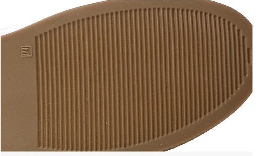 Close-up of a brown textured shoe sole with vertical grooves and a small embossed logo, shown against a white background.