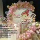 Pink and gold balloon decoration set for a child's birthday party, featuring a large arch backdrop with a cartoon girl illustration and the text 'Maria Alice', plus matching balloon garlands and floral arrangements.
