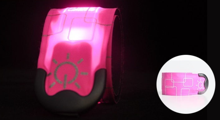 Pink reflective safety vest with a light symbol on a black background
