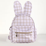 A small bunny-shaped backpack with long ears, featuring a beige and white gingham check pattern and a front zippered pocket with a gold zipper pull.