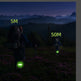 Two people with backpacks and glowing devices in a mountainous landscape at night.