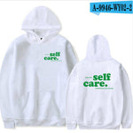 White hoodie with 'self care.' text on front and back, displayed on a white background.