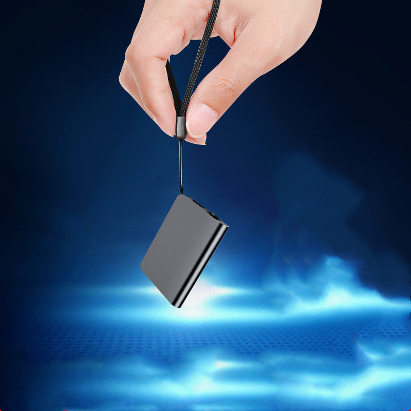Hand holding a small black device with a blue glowing background