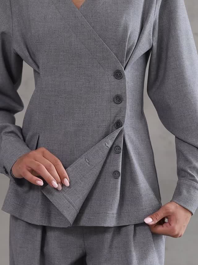 Gray suit jacket with buttons on a plain background