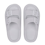 Pair of white slides with buckles on a white background