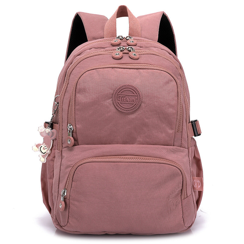 Pink backpack with a visible brand logo on a white background