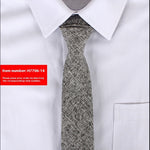 Gray patterned tie on a white shirt with a red item number label.