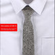 Gray patterned tie on a white shirt with a red item number label.