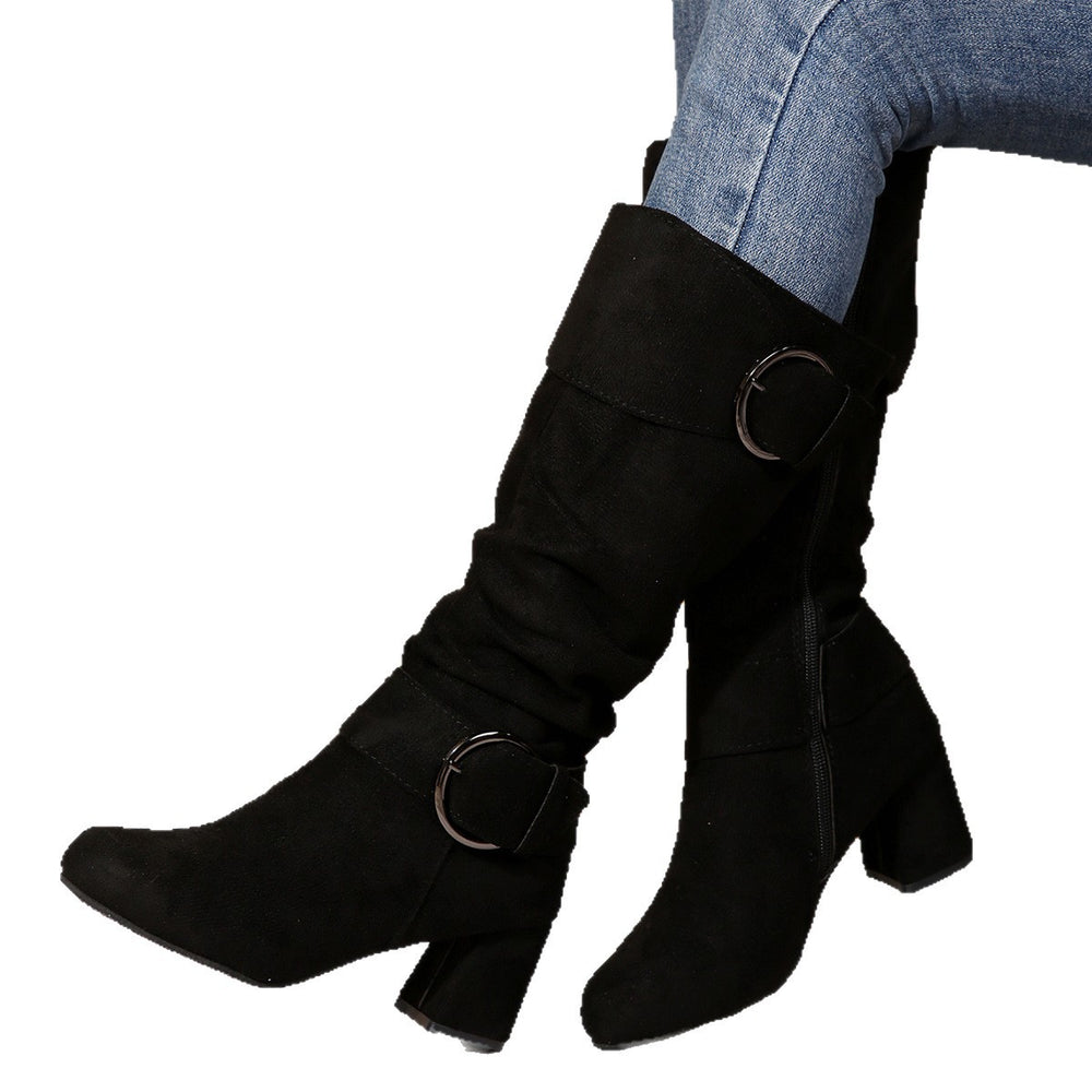 Black knee-high boots with circular buckles worn by a person on a white background
