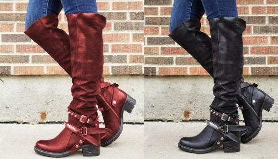 Red and black knee-high boots worn by a person against a brick wall.