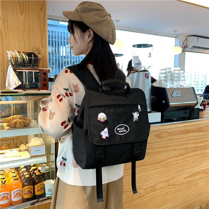 Personne portant un sac à dos noir avec des personnages de dessin animé dans un café.