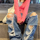 Person wearing ripped jeans and a pink top sitting on steps.