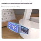 Digital clock with LED display on a desk next to a calendar
