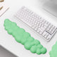 Green gel wrist pad on a keyboard with a laptop and pen in the background