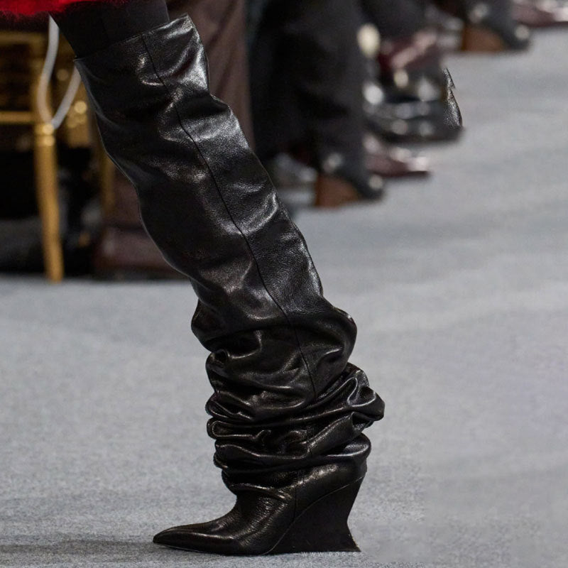 Black leather knee-high boots on a gray carpet