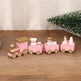 Pink toy train with teddy bears on a wooden surface