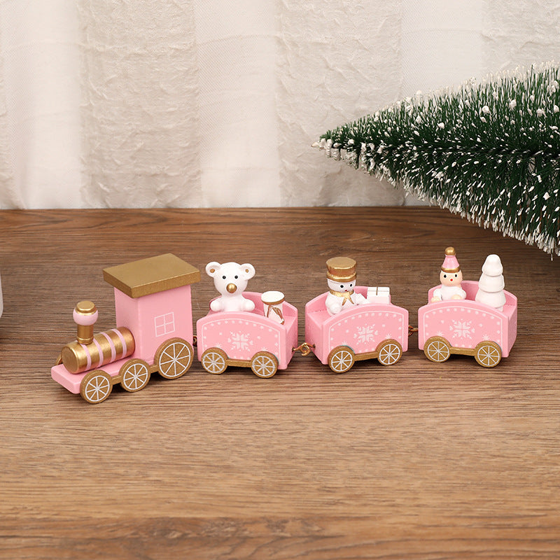 Pink toy train with teddy bears on a wooden surface