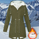 Green winter coat with white fur lining against a snowy mountain background