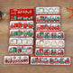 A set of Christmas-themed miniature toy trains and locomotives displayed in multiple red and white gift boxes on a wooden tabletop. The trains feature festive holiday designs including Santa Claus, Christmas trees, snowflakes, and red-and-green holiday patterns.