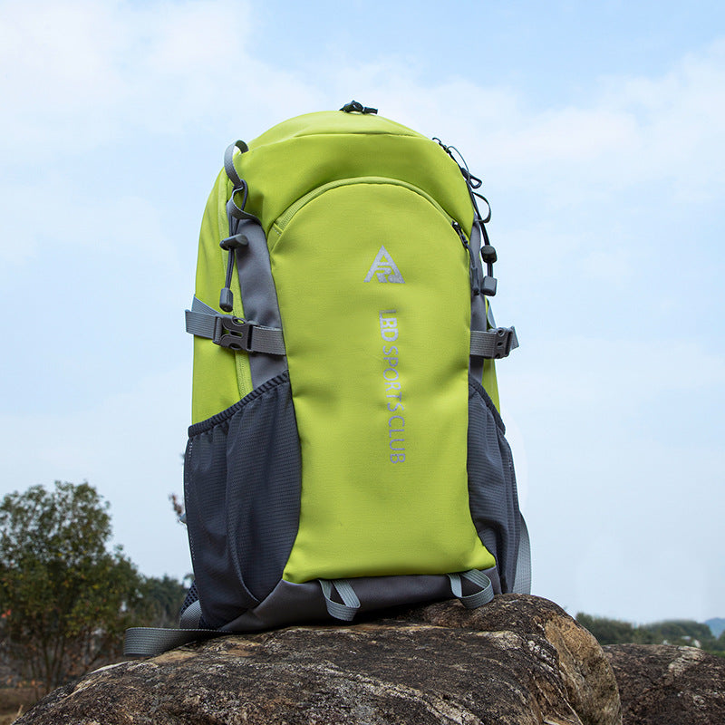 Green and gray backpack on a rock with a blurred natural background