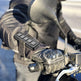 Close-up of a gloved hand on a motorcycle handlebar with a mirror reflection.