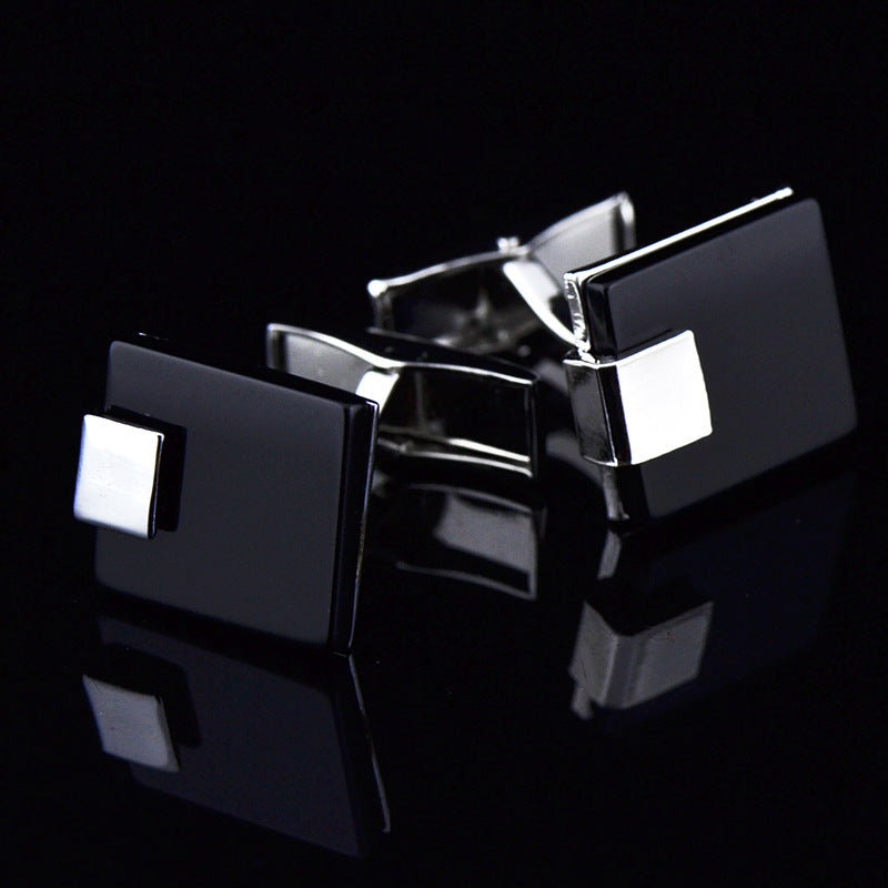 Black and silver square cufflinks on a black background